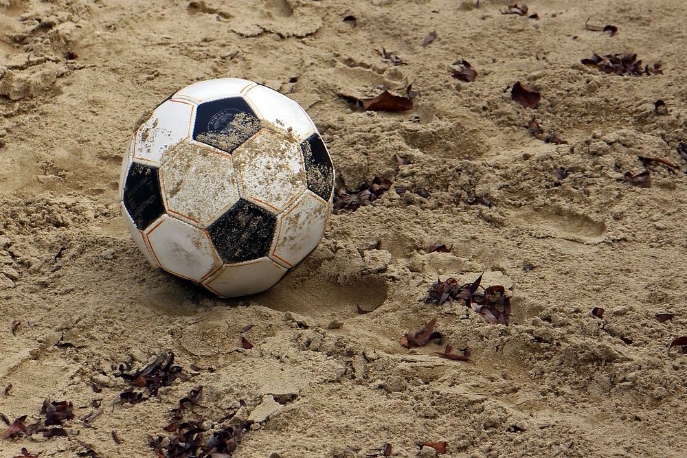 Closeup on soccer ball in soil. Free public domain CC0 photo.