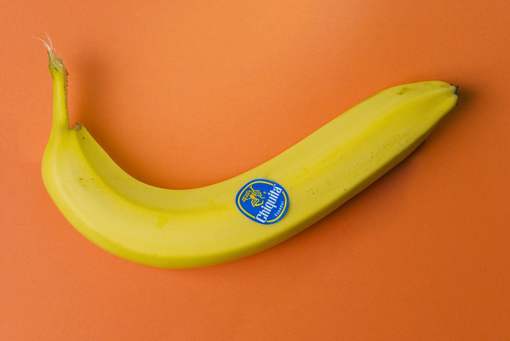 Closeup on yellow banana on orange background. Free public domain CC0 image.