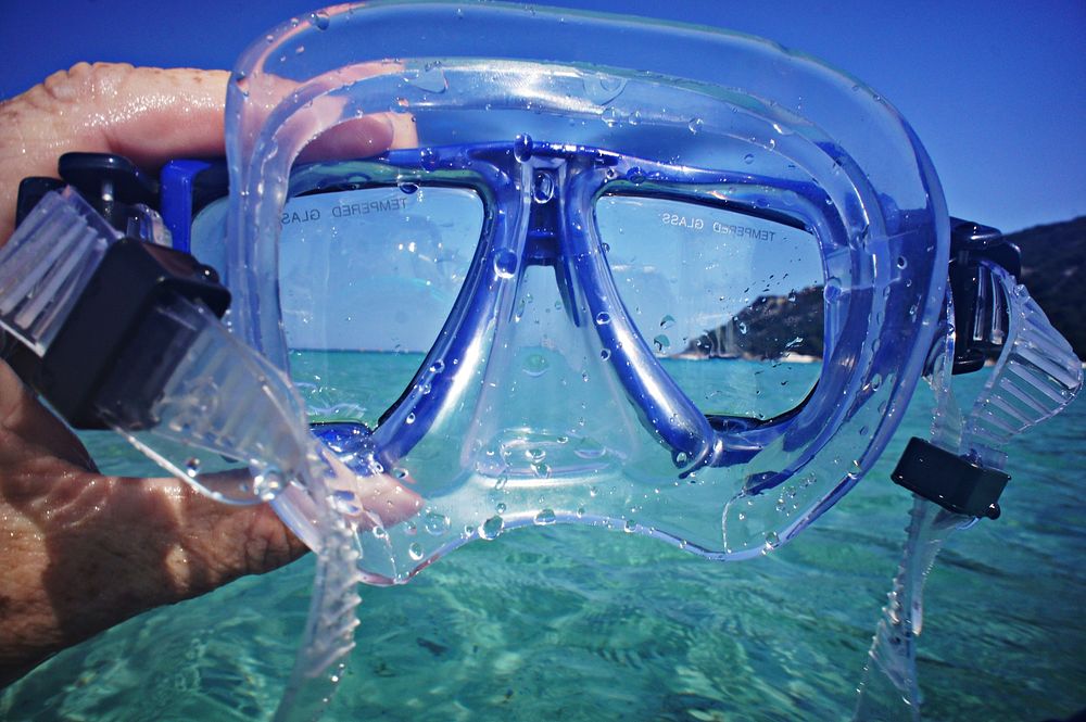 Closeup on snorkeling goggles in ocean. Free public domain CC0 photo.