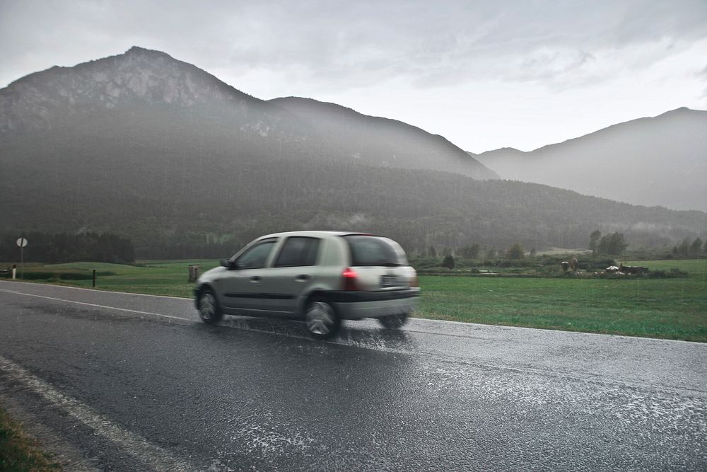 Blur View Of Car on road in the rain with mountain.