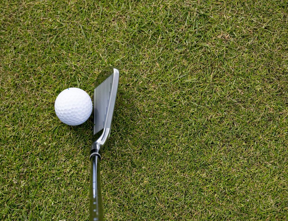 Closeup on golf club head and ball in grass. Free public domain CC0 image. 