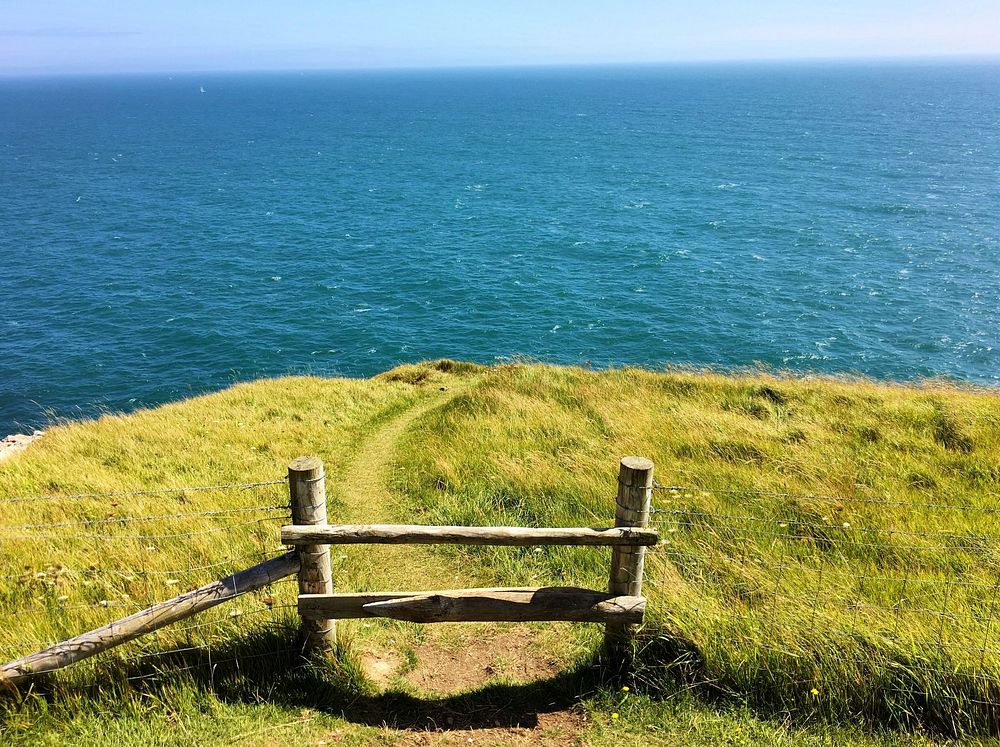 View of Traditional Wooden Stile on Top of a Cliff with green grass. Free public domain CC0 photo.
