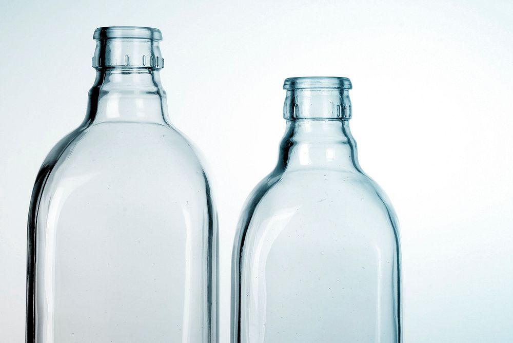 Close up of two glass bottles on white background. Free public domain CC0 photo.