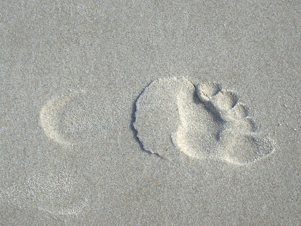 Footprints on beach sand. Free public domain CC0 image.