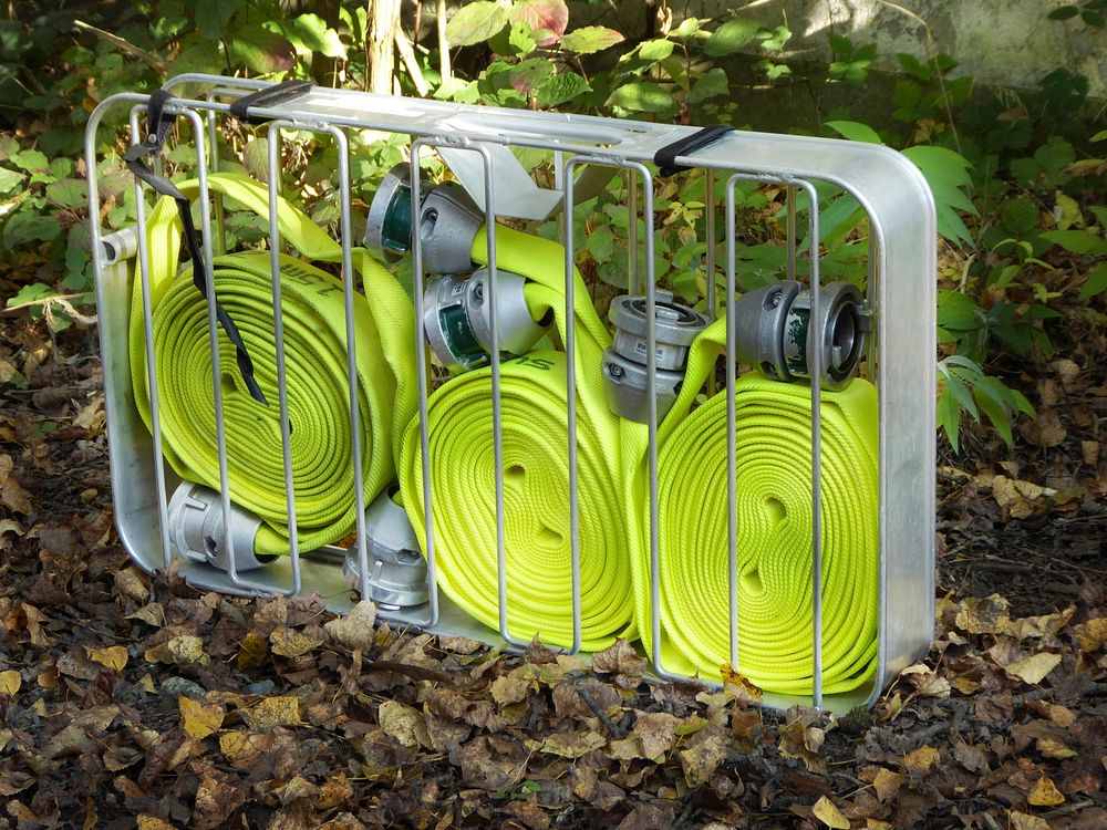 Green fire hose, fire fighting equipment. Free public domain CC0 photo.