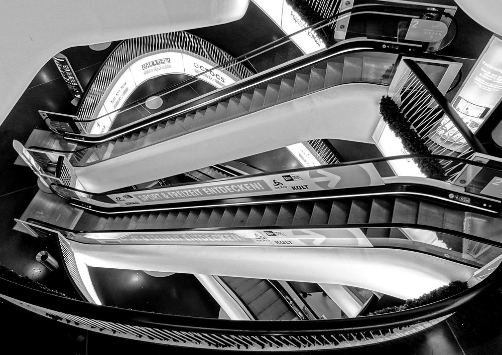 Empty shopping mall escalators in black and white. Free public domain CC0 image.