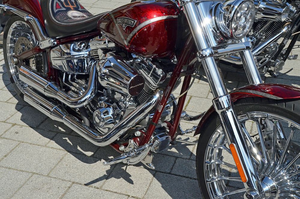 Closeup on red Harley Davidson classic motorcycle, location unknown, 13 May 2016. View public domain image source here