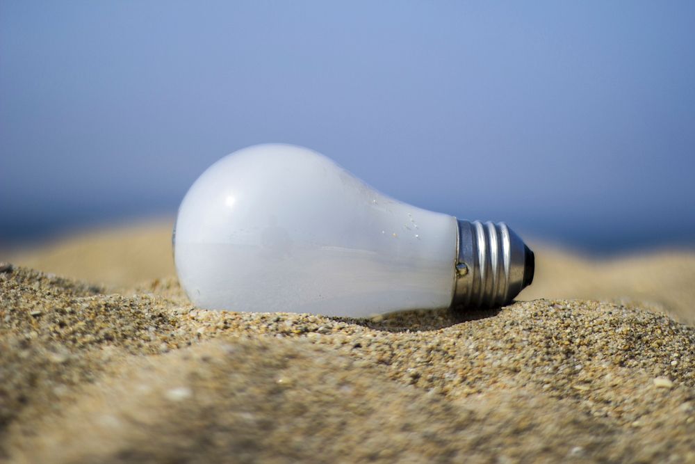 Light bulb on sand. Free public domain CC0 photo.