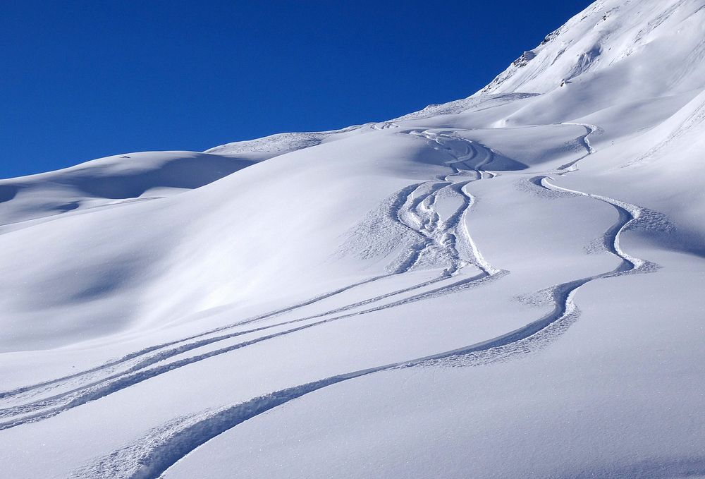 Ski tracks on snow in mountain. Free public domain CC0 photo.