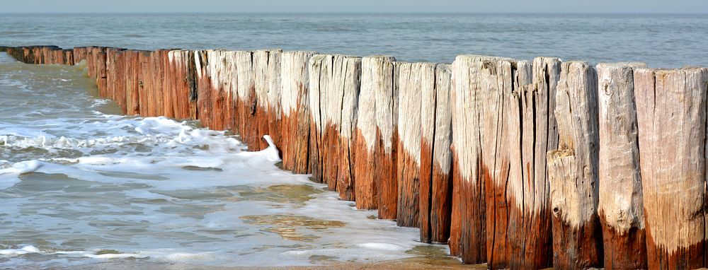 wood water break across the beach. Free public domain CC0 photo.