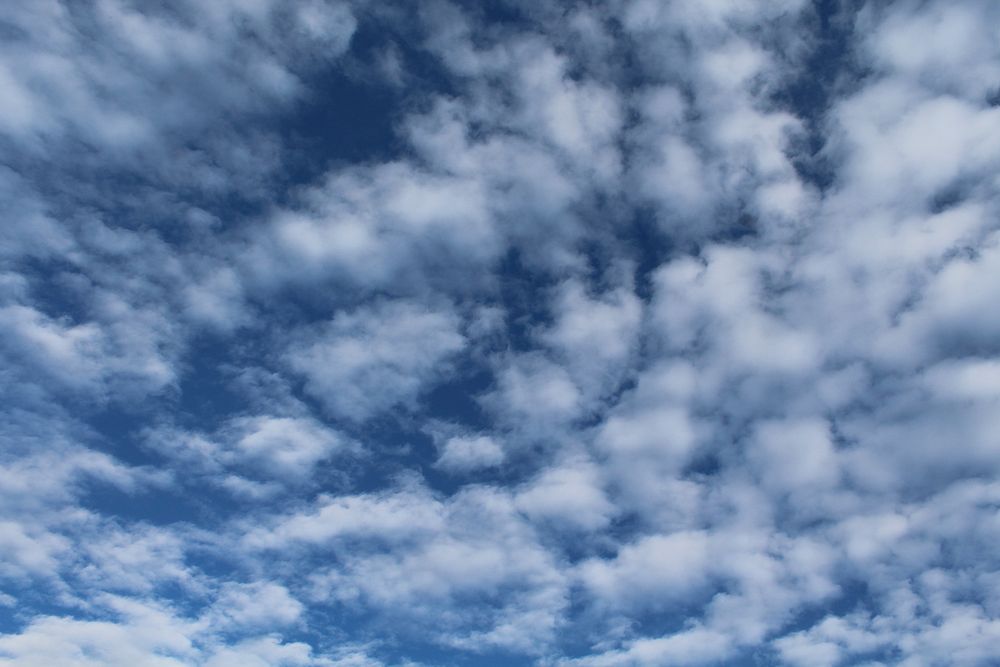 Blue sky background with clouds. Free public domain CC0 image.