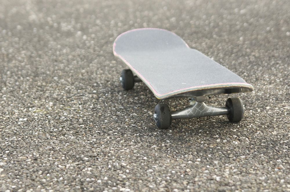 Closeup of skateboard on asphalt. Free public domain CC0 photo.