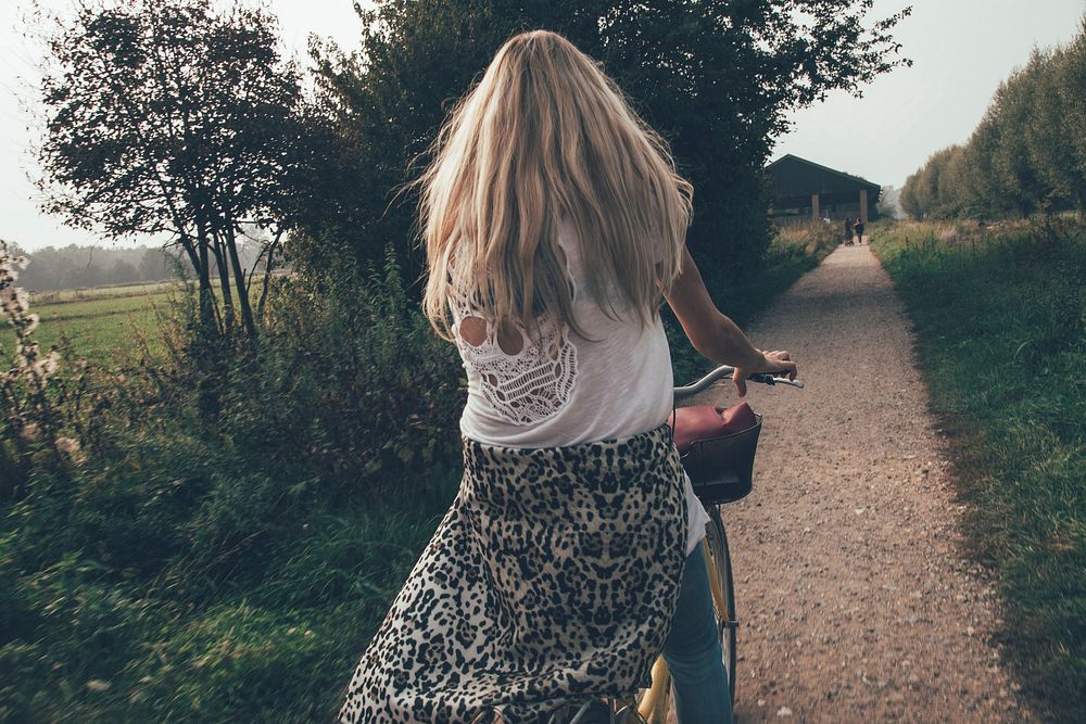 Free woman cycling in countryside photo, public domain human CC0 image.