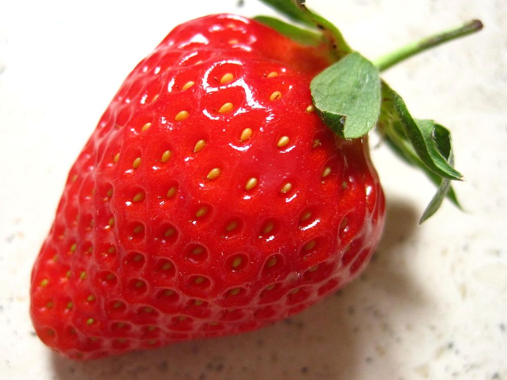 Closeup on fresh strawberry on table. Free public domain CC0 image.