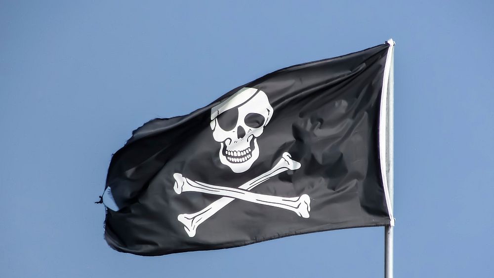 Pirate flag against blue sky, free public domain CC0 photo.