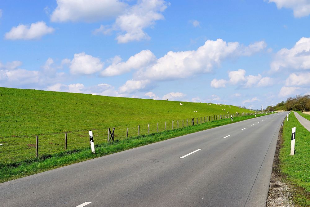 Road along green grass hill. Free public domain CC0 photo.