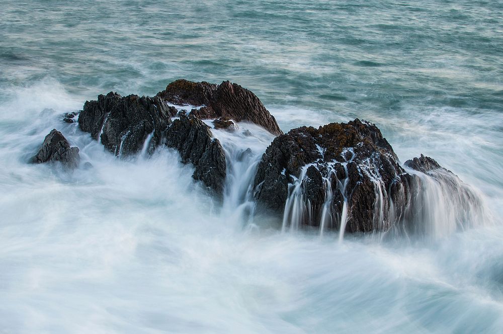 Sea waves washing over rocks. Free public domain CC0 photo.