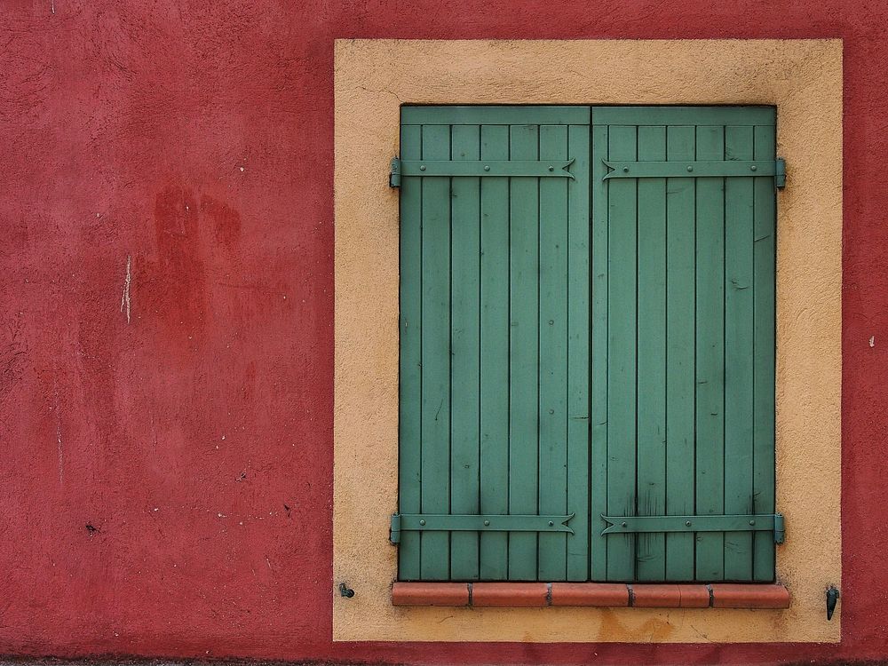 Red wall with green wooden window. Free public domain CC0 photo.