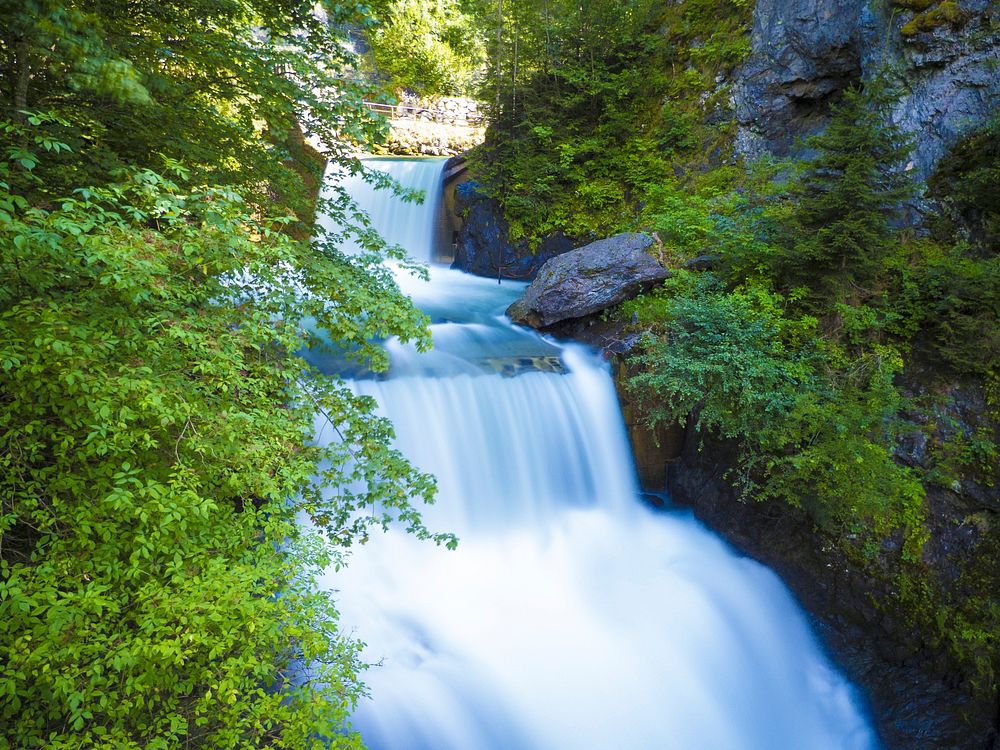 Beautiful flowing waterfall around nature. Free public domain CC0 image.