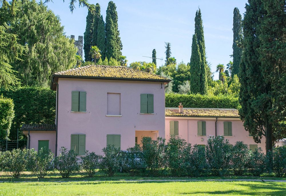 Pink house surrounded by green trees. Free public domain CC0 photo.