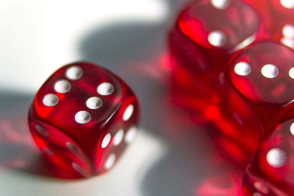 Red dice on the table close up, free public domain CC0 photo.