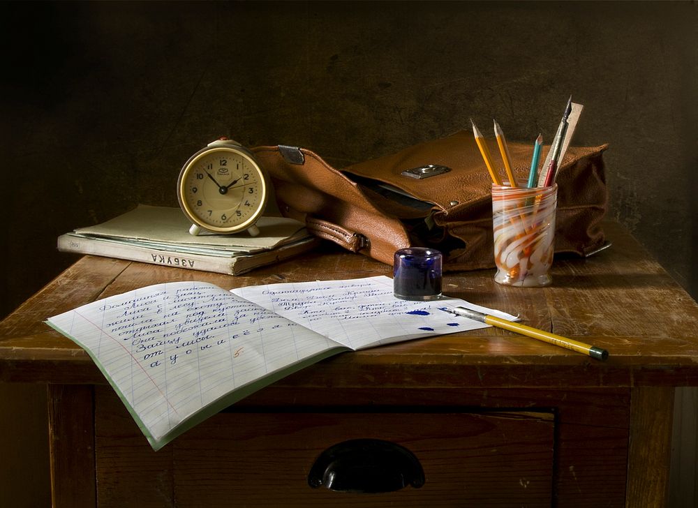 Free study table with stationery and clock image, public domain CC0 photo.
