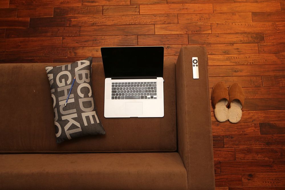 Free laptop on brown sofa image, public domain interior design CC0 photo.