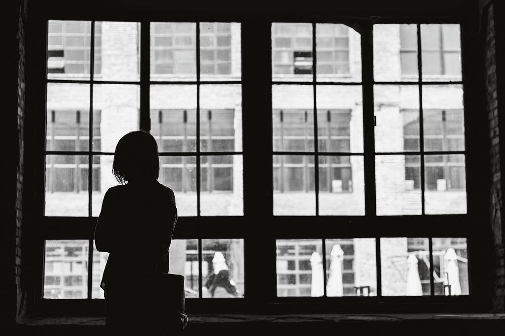 Free black and white woman stands near window image, public domain person CC0 photo.