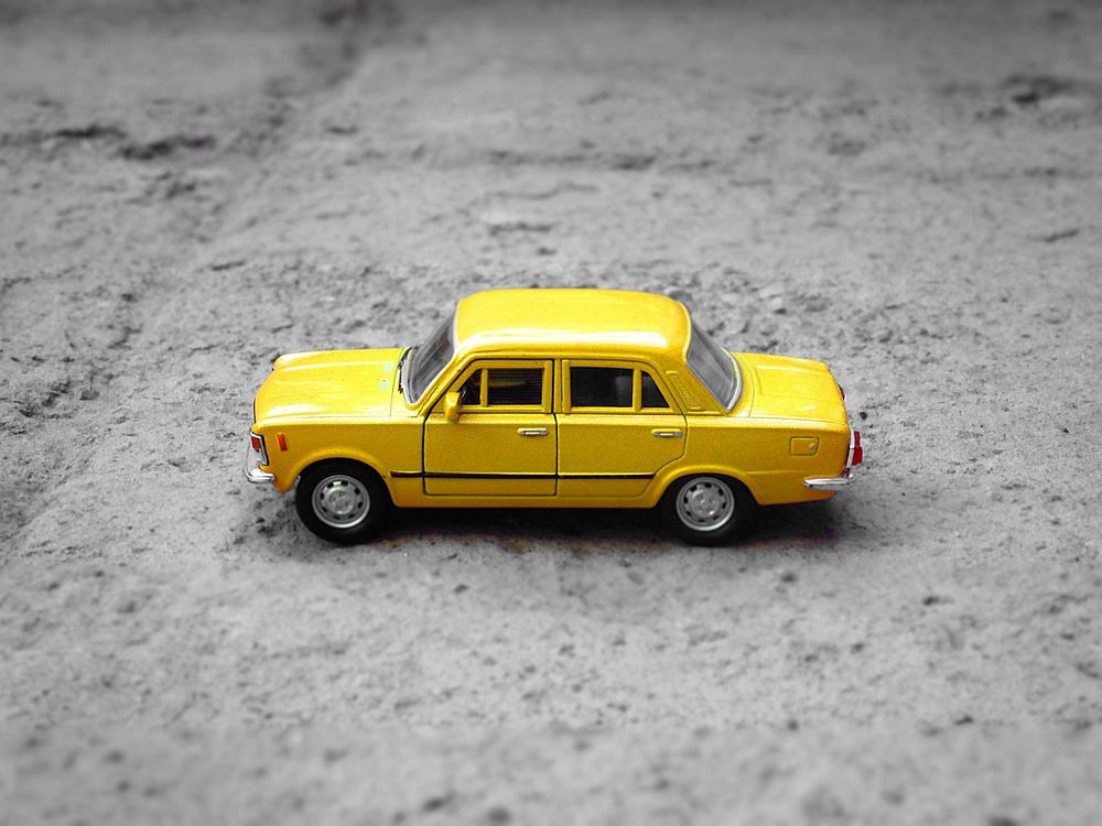 Free yellow car toy on street, public domain car CC0 photo.