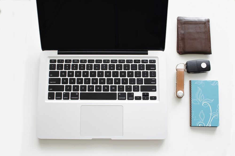 Free workspace flat lay with laptop, notebook, car key and purse image, public domain CC0 photo.