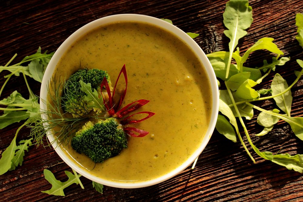 Free yellow creamy vegetable soup with broccoli table top view photo, public domain food CC0 image.