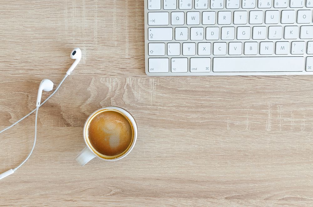 Free coffee cup, keyboard, earphones on wooden background photo, public domain beverage CC0 image.