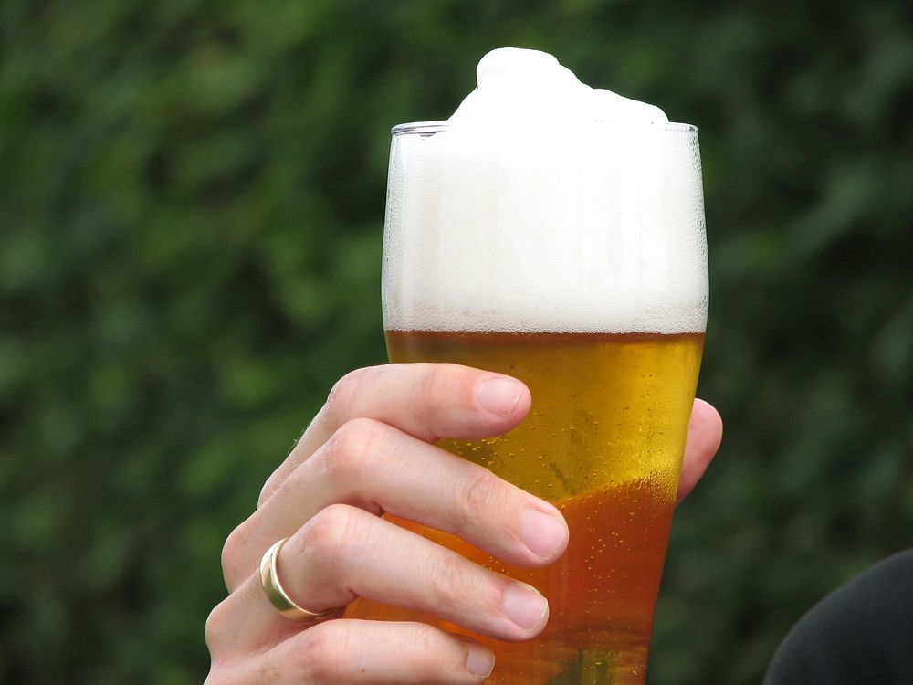 Person holding beer image, free public domain alcohol drink CC0 photo.