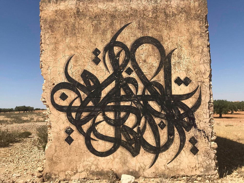 Free Arabic calligraphy graffiti on stone image, public domain CC0 photo.