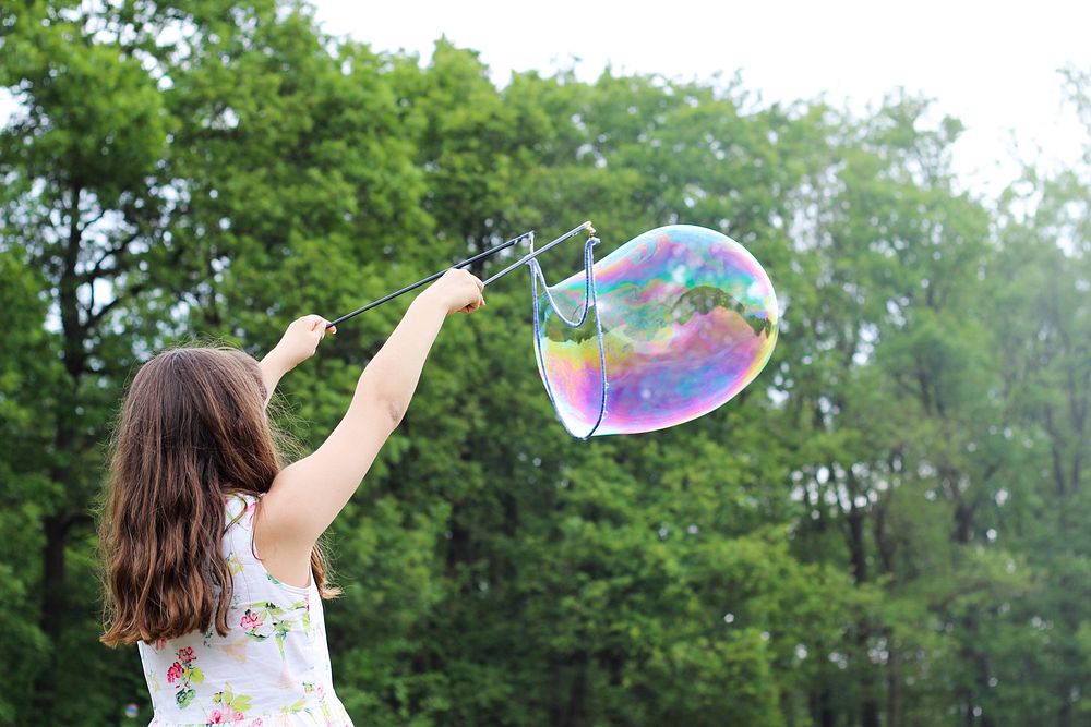 Free girl playing soap bubbles photo, public domain human CC0 image.