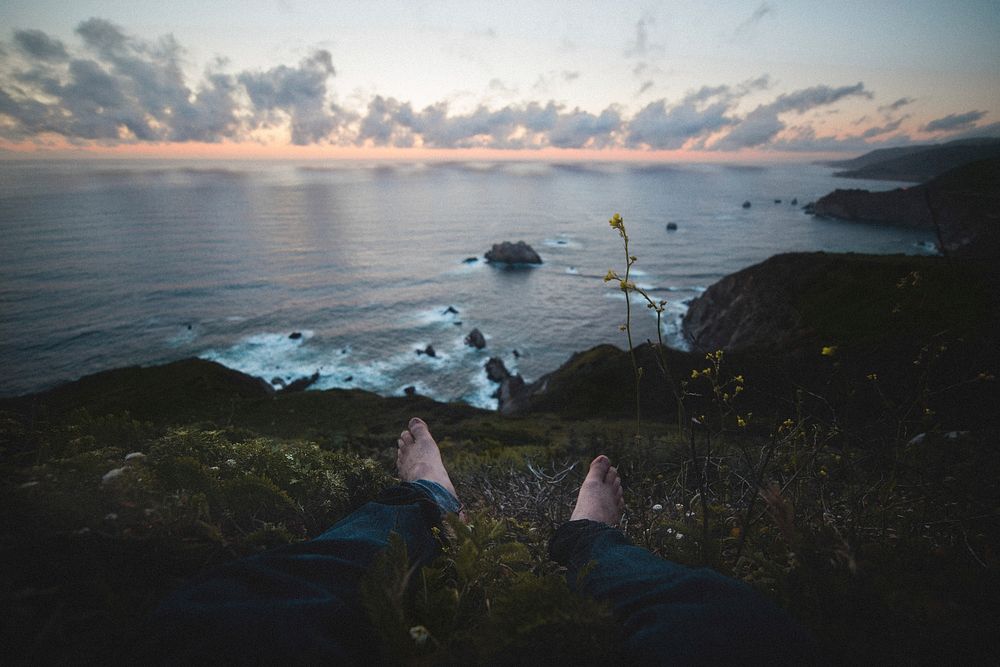 Sitting on cliff facing ocean, free public domain CC0 photo.