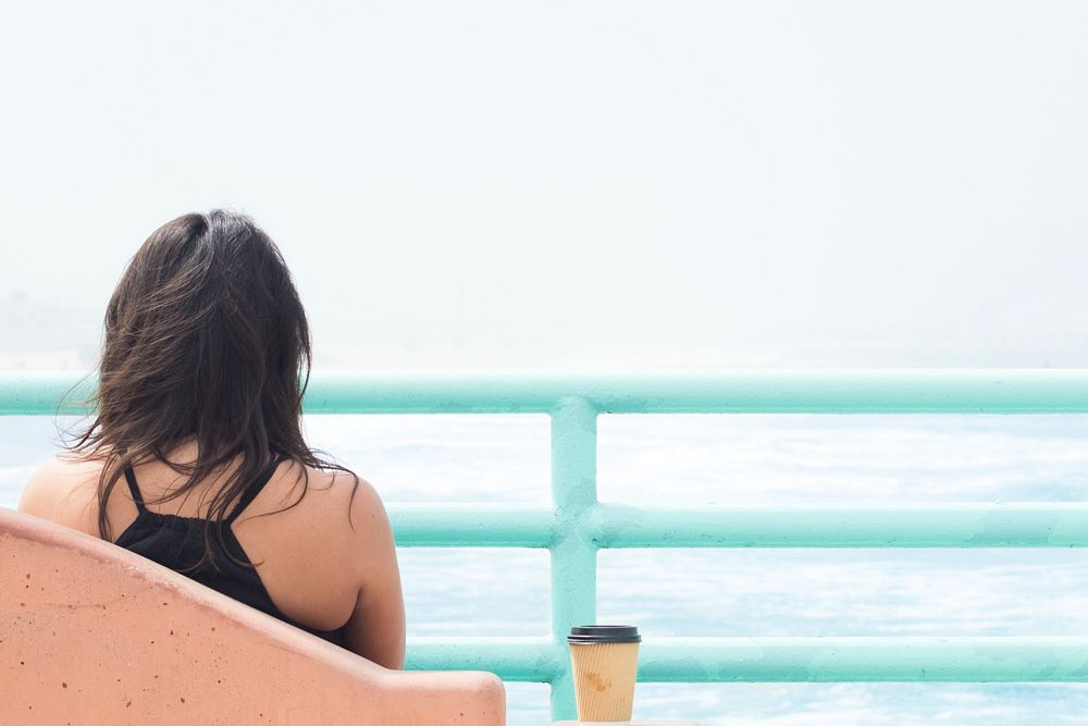 Free woman sitting by the sea photo, public domain travel CC0 image.