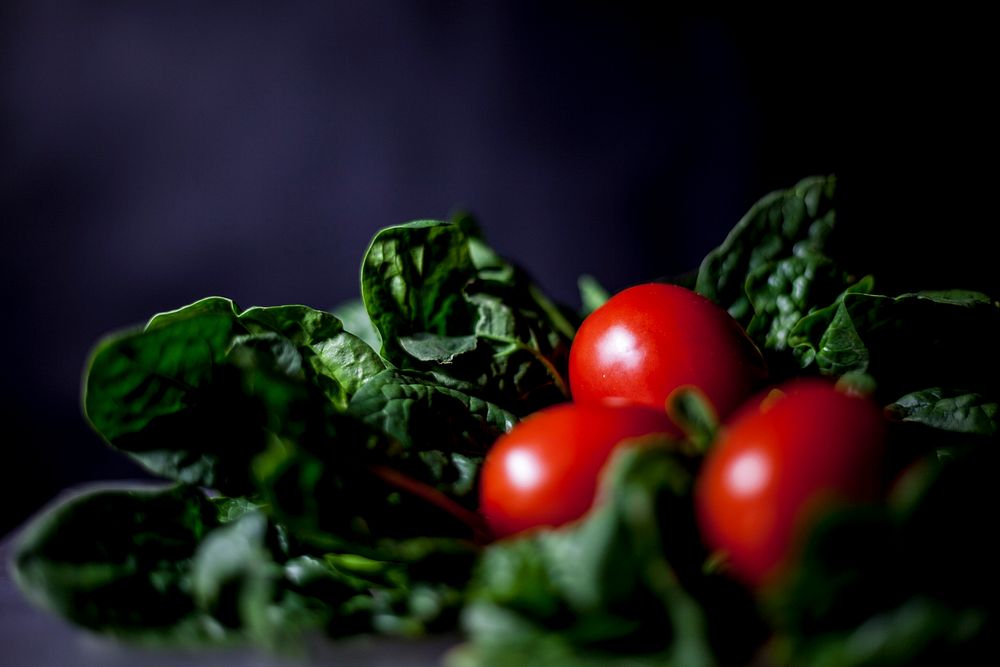 Free fresh tomatoes and spinach on black background photo, public domain CC0 image.