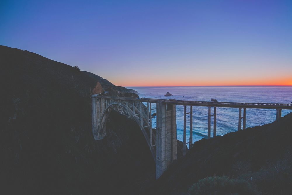 Bridge over aesthetic beach sunset, free public domain CC0 photo.