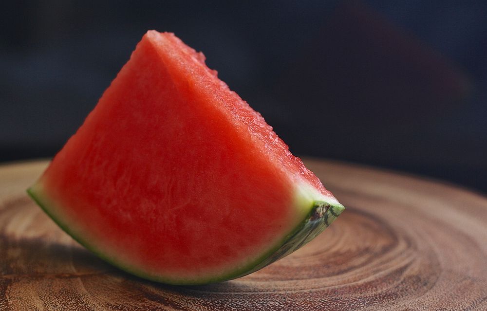 Free watermelon slice on wooden table photo, public domain CC0 image.