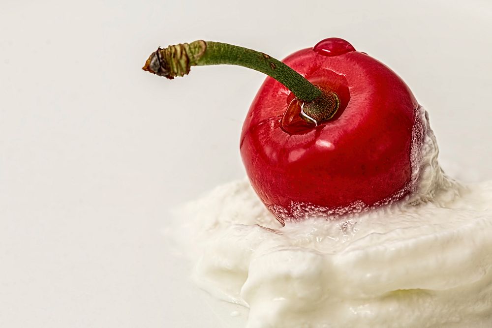 Free red cherry on yogurt cream close up photo, public domain fruit CC0 image.