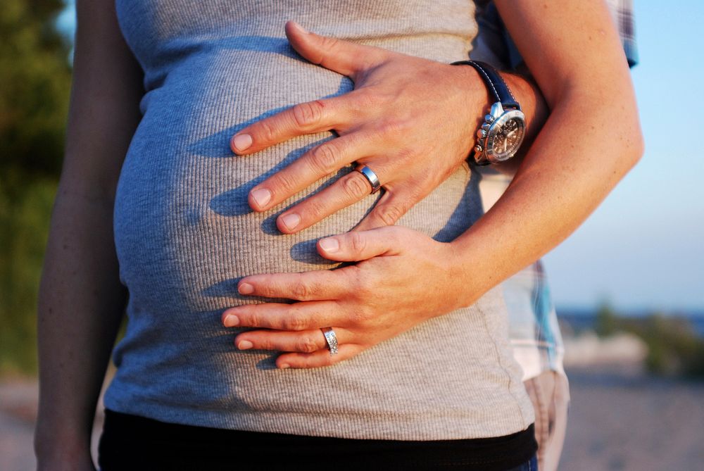 Free pregnant woman showing wedding rings image, public domain love CC0 photo.