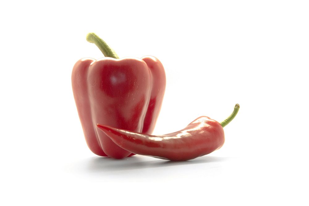 Free closeup of red bell pepper and chili pepper on white background, public domain CC0 photo.