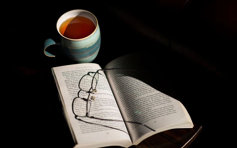 Free glasses on open book with a cup of tea photo, public domain CC0 image. 