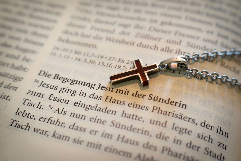 Free red cross necklace on open Bible image, public domain accessory CC0 photo.