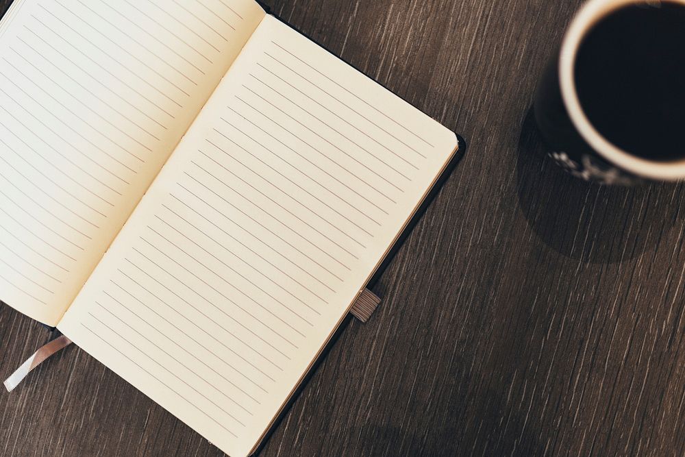 Free blank open notebook on wooden table with coffee cup photo, public domain CC0 image.