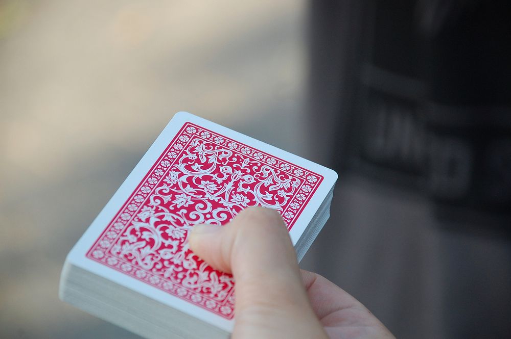 Free hand holding playing cards image, public domain CC0 photo.