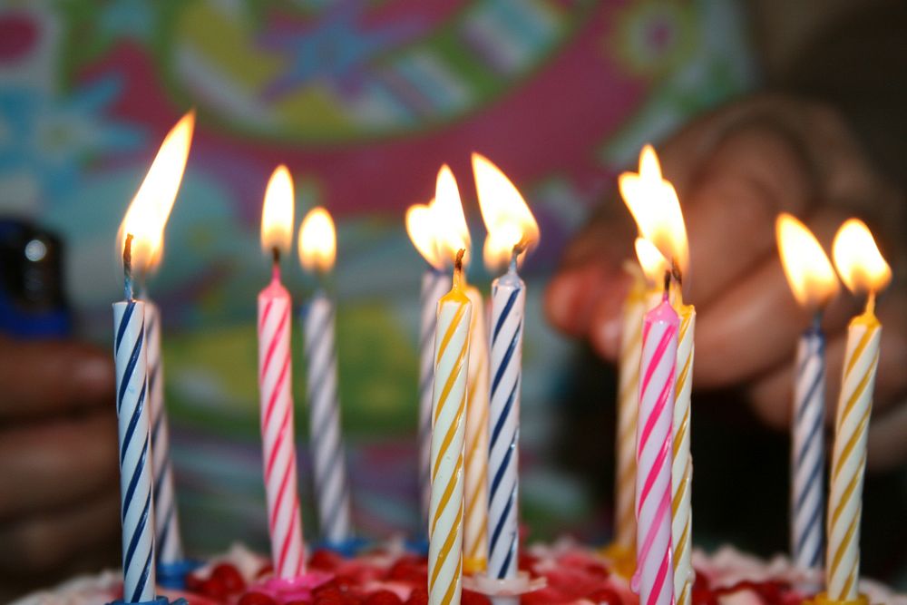 Free birthday cake with lit candle image, public domain CC0 photo.