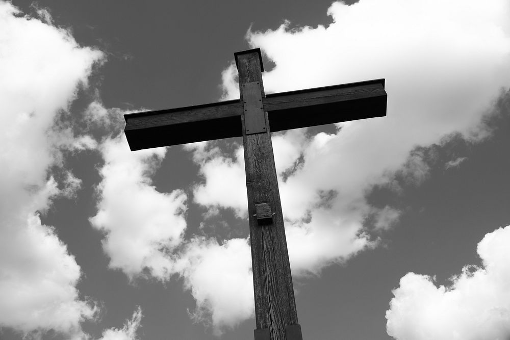 Cross in cloudy sky black and white background, free public domain CC0 photo.