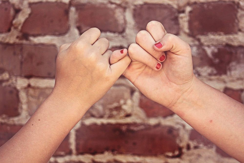 Pinky promise, bestfriend bond with brick wall background photo, free public domain CC0 image.